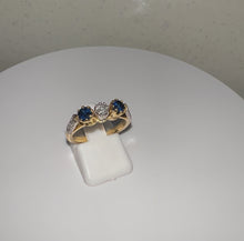 Load and play video in Gallery viewer, 18ct Yellow Gold Round Brilliant Cut Diamond &amp; Sapphire Trilogy Ring
